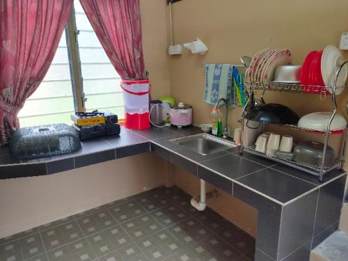 a kitchen with a sink and a counter top at NUR RAMADHAN CAMPSITE in Tanjung Malim