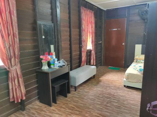 a bedroom with a bed and a table with a desk at NUR RAMADHAN CAMPSITE in Tanjung Malim