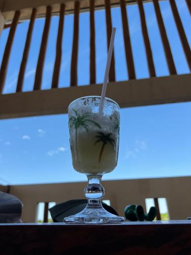 a drink with a straw in a glass on a table at CasAMAR lençóis in Santo Amaro