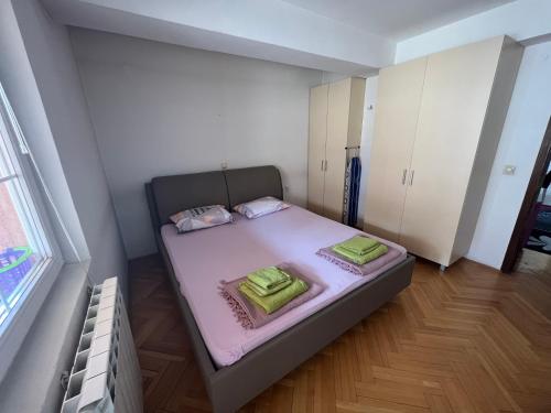 ein kleines Schlafzimmer mit einem Bett mit rosa Bettwäsche in der Unterkunft Centar Luxory Apartmans in Skopje