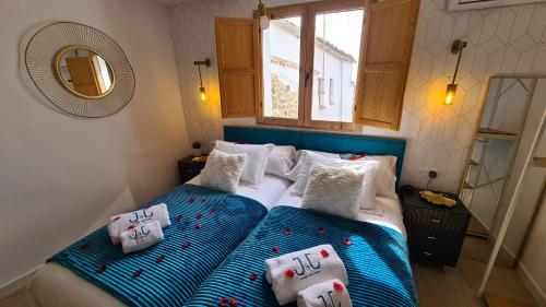 a bedroom with two beds with pillows and a mirror at El Edén Casas Rurales con Piscina y Jacuzzi in Montánchez