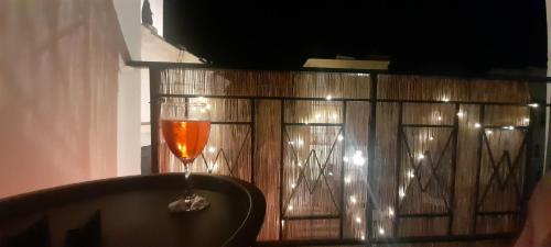 a glass of wine sitting on top of a table at I Cappuccini B&B in Sorso