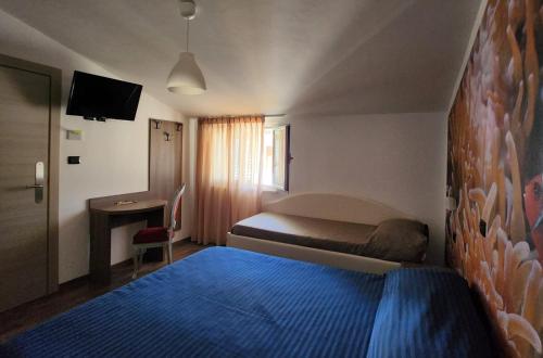 a hotel room with a blue bed and a desk at Hotel Miramare Dipendenza in Pineto
