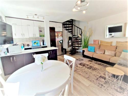 uma cozinha e sala de estar com uma mesa branca e cadeiras em Ducal 9 Manga Norte em La Manga del Mar Menor