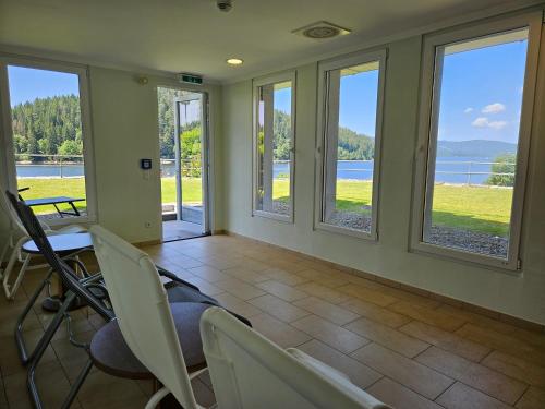 a dining room with windows and a table and chairs at Seehotel Hubertus in Schluchsee
