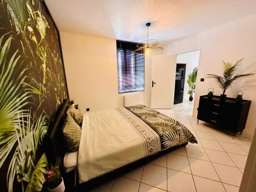 a bedroom with a large bed in a room at Le Tropical sublime ambiance Jungle proche Metz in Noisseville