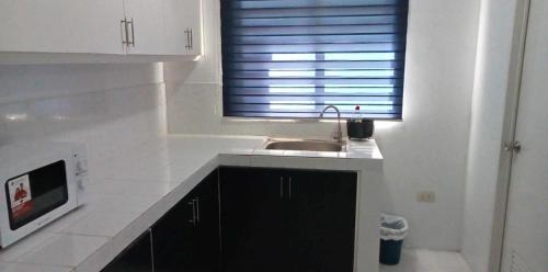 a white kitchen with a sink and a window at MM & Naomi staycation in Mexico