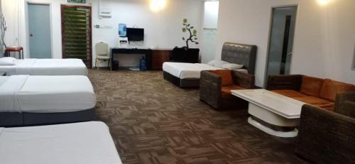 a hotel room with two beds and a couch at Golden Leaf Hotel Danga Bay in Johor Bahru