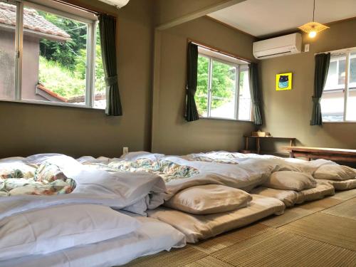 a large bed sitting in a room with windows at TORUS 修善寺 Condominium 貸切宿 in Izu