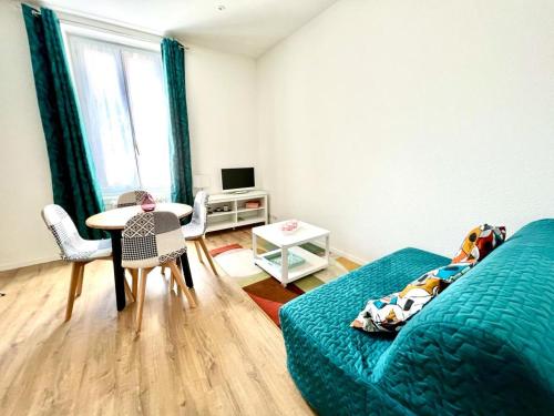 1 dormitorio con 1 cama y 1 mesa con sillas en Le Gamay - Charmant T2 avec parking et Terrasse en Châtel-Guyon