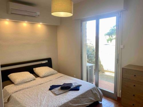 - une chambre avec un lit et une grande porte en verre dans l'établissement Beau T3 - plain pied - terrasses, à Port-la-Nouvelle