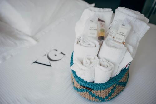 a group of towels in a basket on a bed at Villa Giulietta Hotel in Castiglioncello