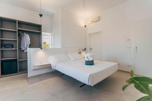 a white bedroom with a bed and a table at Villa Giulietta Hotel in Castiglioncello
