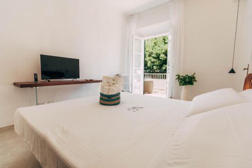 a white bedroom with a bed and a tv at Villa Giulietta Hotel in Castiglioncello