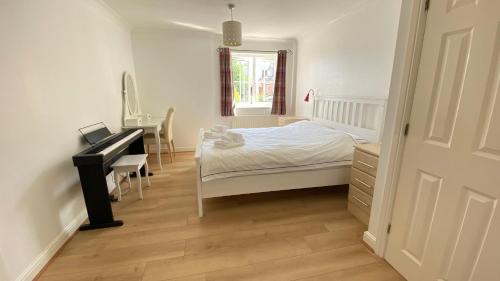 um quarto com uma cama, uma secretária e um piano em Sweet home 2 Double bedrooms apartment free parking Summertown, Oxford em Oxford