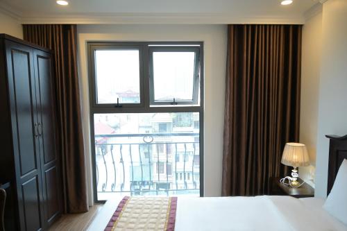 a hotel room with a bed and a large window at Mercy Hotel in Hanoi