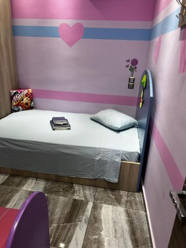 a small bedroom with a bed with a heart on the wall at MESAGGALA PALACE No 2 FIRSTLINE SEA in Néa Meságkala