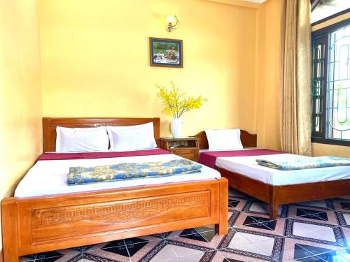 1 dormitorio con 2 camas en una habitación en Khách Sạn Đô Thành, en Ha Long