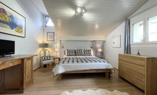 una camera con letto e TV a schermo piatto di Luxury Alpine Retreat with Wellness Area a Flims