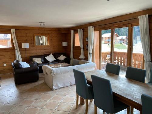un soggiorno con un tavolo e un divano di Chalet Cannon- Mountain Getaway a Les Contamines-Montjoie