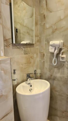 bagno con lavandino bianco e specchio di Hotel Petunia a Néos Marmarás