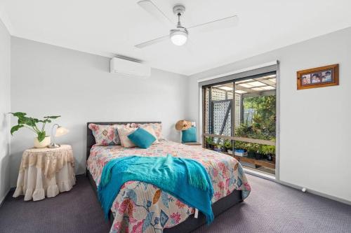un dormitorio con una cama y una ventana en Sunset Retreat with Water Views, en Lakes Entrance