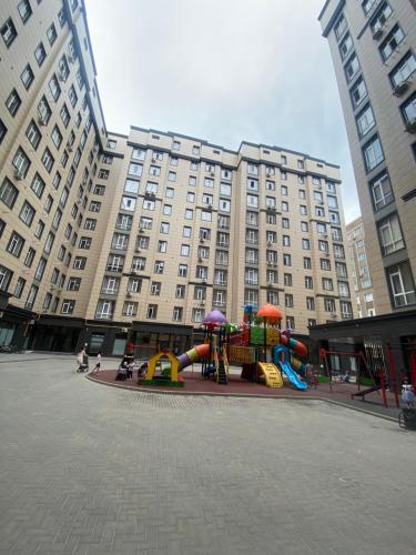 een speeltuin voor een groot gebouw bij Elizavetta in Bisjkek