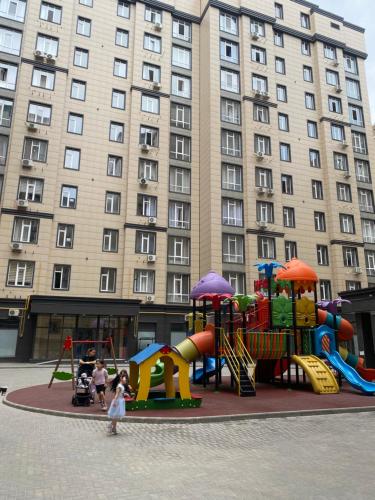 a playground in front of a large building at Elizavetta in Bishkek