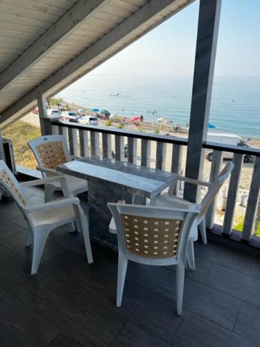 a table and chairs on a balcony with a view of the ocean at MESAGGALA PALACE No 3 FIRSTLINE SEA in Néa Meságkala
