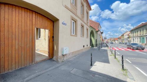 a building with a wooden door on the side of a street at Long street suites in Braşov