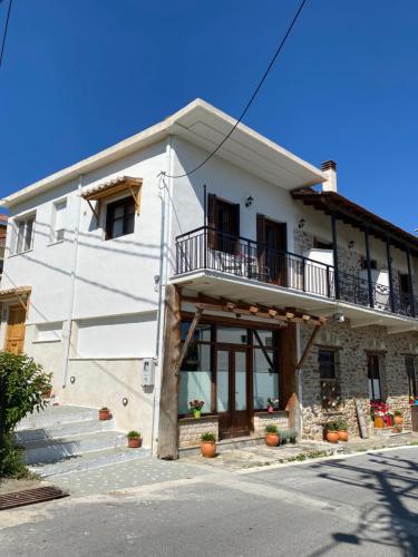 a white house with a balcony on the side of it at 1924 Studios 1 in Áyios Pétros