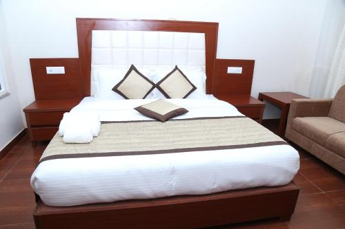 1 dormitorio con 1 cama grande y 1 sofá en The Grand Kartikeye Hotel & Banquet Destination en Pālampur