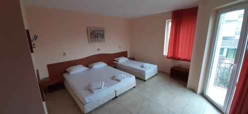 uma sala de estar com duas camas e uma janela em Hotel Morski Dar em Kranevo