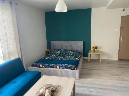 Zimmer mit einem Bett, einem Sofa und einem Tisch in der Unterkunft La Pause Pétillante in Sélestat