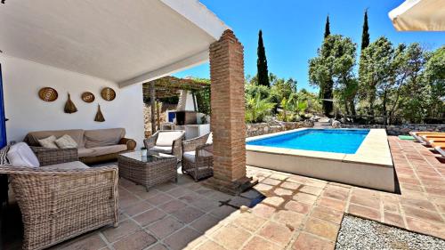 a patio with a swimming pool and a villa at Casa Rural Liviana, Piscina Barbacoa y preciosas vistas Málaga by AndaraHolidays in Cómpeta