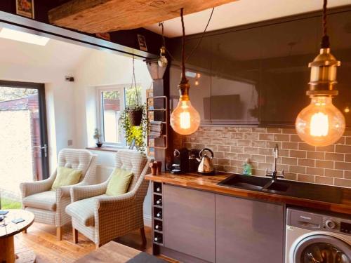 a kitchen with pendant lights hanging over a counter at Beach & Open air theatre-2x Pubs -5 min walk-Parking-Garden in Scalby