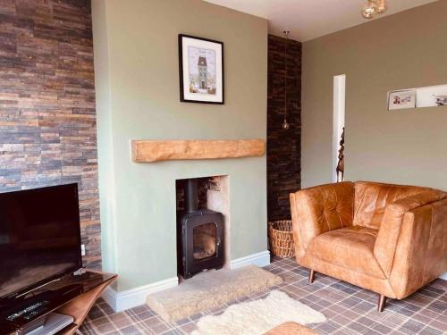 a living room with a chair and a fireplace at Beach & Open air theatre-2x Pubs -5 min walk-Parking-Garden in Scalby