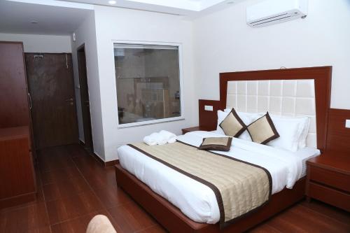 Un dormitorio con una cama grande y una ventana en The Grand Kartikeye Hotel & Banquet Destination en Pālampur