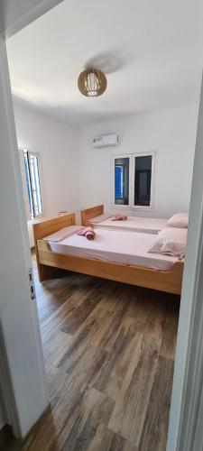 a bedroom with a large bed and a wooden floor at debi's place in Linariá