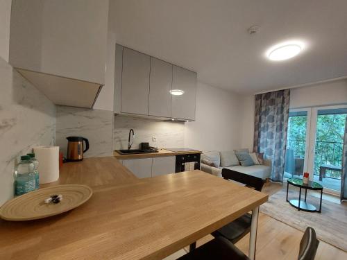 een keuken en een woonkamer met een houten tafel bij Komfort z balkonem w centrum in Wrocław