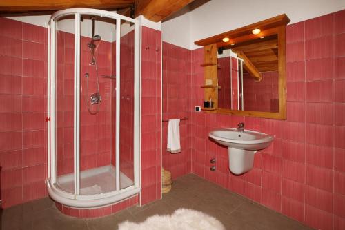 a red tiled bathroom with a shower and a sink at Chalet Faure in Sauze dʼOulx