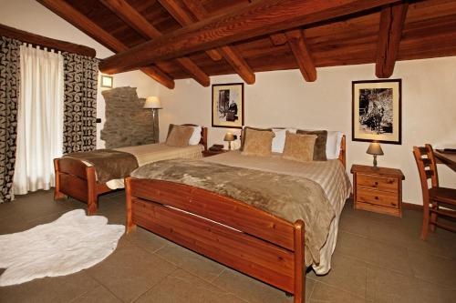 サウゼ・ドゥルクスにあるChalet Faureのベッドルーム1室(ベッド2台、テーブル、椅子付)