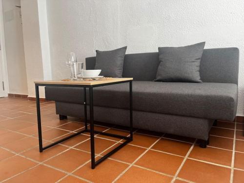 a gray couch with a table and a table at Suite en el corazón de Doñana in El Rocío
