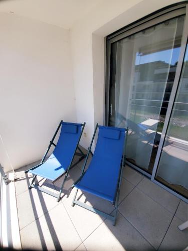 - deux chaises bleues assises sur un balcon dans l'établissement Le Carré des Sens, à La Rochelle