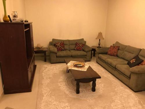 a living room with two couches and a coffee table at 2 Bed Room Apparment in Amman - Der Ghbar in Amman