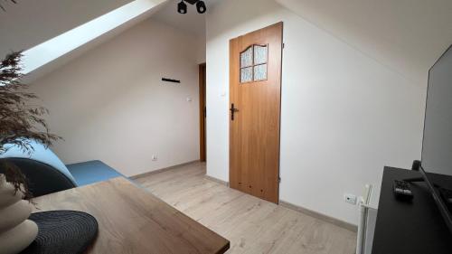 a room with a wooden door and a wooden table at Kraken-pokoje gościnne in Krynica Morska