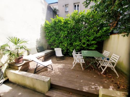 d'une terrasse avec un canapé, des chaises et une table. dans l'établissement La Maison de ville 76m2 avec terrasse de 22m2, à La Rochelle