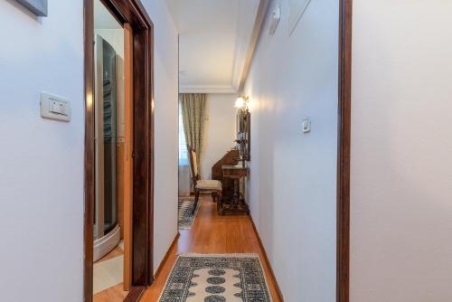 a hallway with a mirror and a rug on a floor at Heritage Hotel Pasike in Trogir
