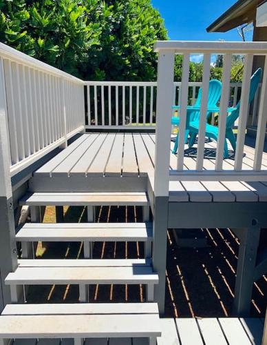 a wooden deck with a bench and chairs at North Shore Garden Studio in Haleiwa