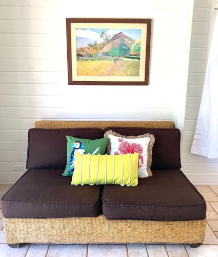 a brown couch with pillows on it in a room at North Shore Garden Studio in Haleiwa